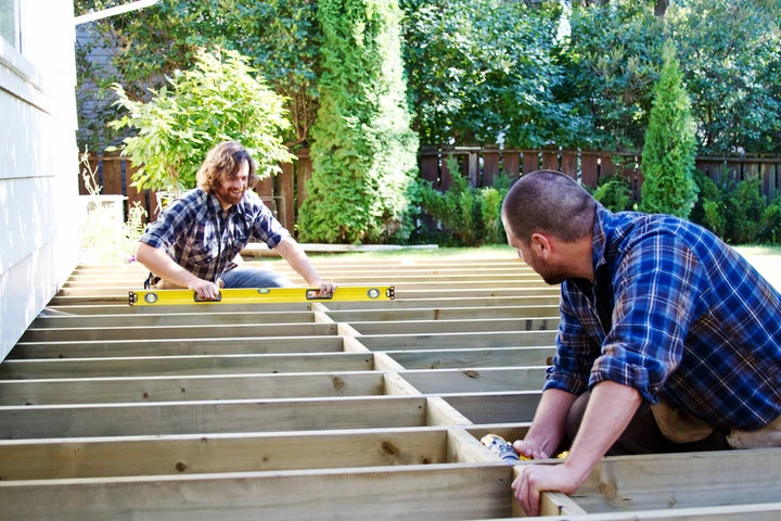 Professional deck installation with skilled contractors using precision tools